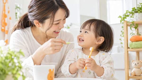 保護者と1歳児が歯ブラシを持って楽しく歯みがきの準備をする様子