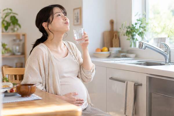 食後に水でやさしくうがいをする妊婦さん