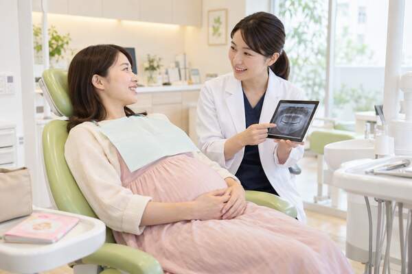 妊婦さんが楽な姿勢で歯科検査の説明を受ける様子