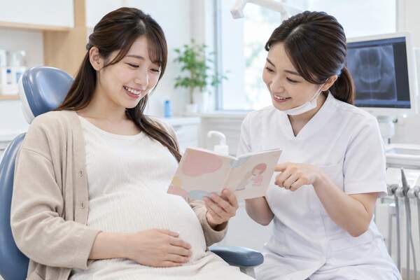 妊婦さんと歯科医師が母子健康手帳を確認する様子